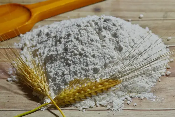 Farine et épis de blé sur une table en bois